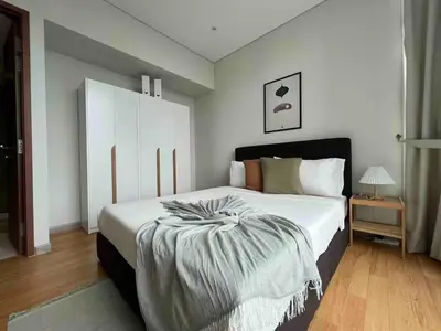 a bedroom with a large white bed and a table at Nook Sky Suites KLCC in Kuala Lumpur