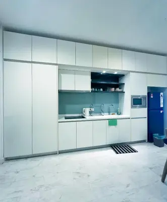 a kitchen with white cabinets and a blue refrigerator at Platinum Suites Kuala Lumpur Malaysia By LuzBnB in Kuala Lumpur