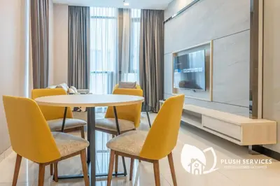 a dining room with a table and chairs and a tv at Societe Suites Hartamas by Plush in Kuala Lumpur
