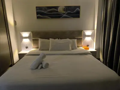 a bedroom with a large white bed with two shoes on it at Sky View Agile Residence Bukit Bintang KL in Kuala Lumpur