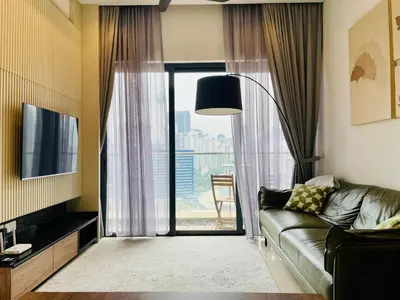 a living room with a couch and a large window at Lucentia Residences By ONZO in Kuala Lumpur