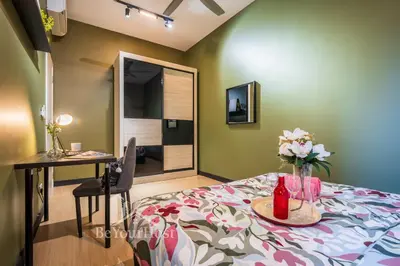 a room with a bed and a table with flowers on it at Continew Residences Kuala Lumpur in Kuala Lumpur
