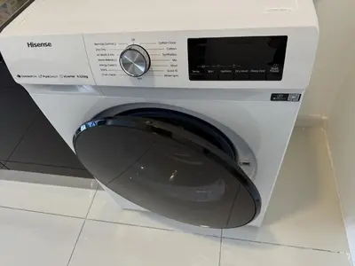 a white washing machine sitting on top of a counter at The Majestic Residence Kuala Lumpur in Kuala Lumpur