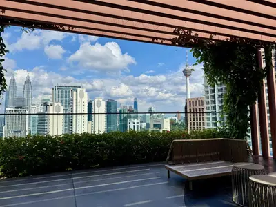 a bench on a balcony with a view of the city at The Majestic Residence Kuala Lumpur in Kuala Lumpur