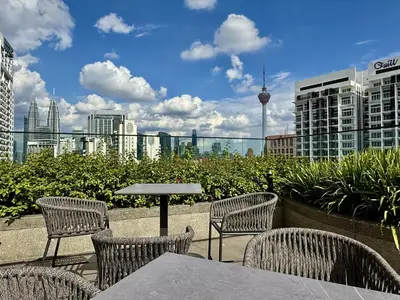 a table and chairs with a view of the city at The Majestic Residence Kuala Lumpur in Kuala Lumpur