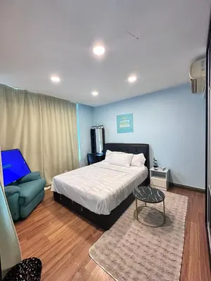 a bedroom with a bed and a table and a couch at Taragon Puteri Bintang KL in Kuala Lumpur