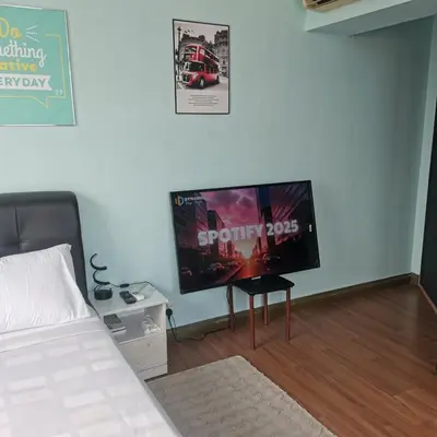 a bedroom with a bed and a flat screen tv at Taragon Puteri Bintang KL in Kuala Lumpur