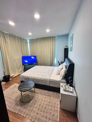 a bedroom with a large bed and a table and a table sidx sidx at Taragon Puteri Bintang KL in Kuala Lumpur