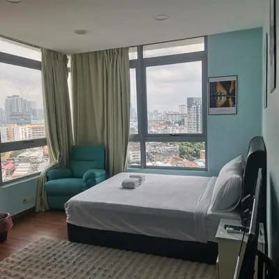 a hotel room with a bed and a large window at Taragon Puteri Bintang KL in Kuala Lumpur