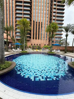 a large swimming pool with palm trees and buildings at Times Square KL Serviced Suite in Kuala Lumpur