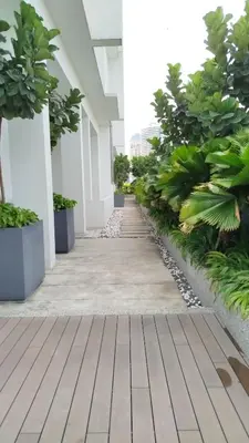 a walkway in a building with trees and plants at Quill Residence KLCC Suites City Home in Kuala Lumpur