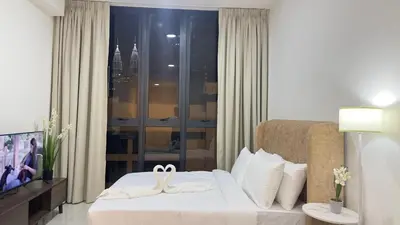 a hotel room with a bed with two white towels at KLCC view suite 1601B at Majestic Residence in Kuala Lumpur