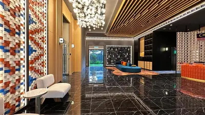 a lobby with a chandelier and a blue couch at KLCC view suite 1601B at Majestic Residence in Kuala Lumpur
