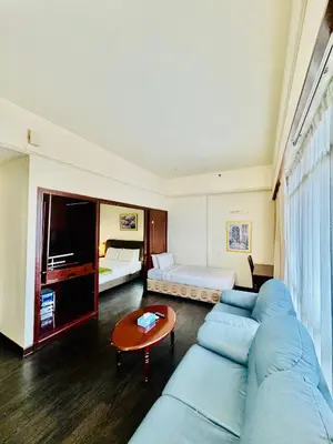 a living room with a blue couch and a bedroom at Signature Suite at Time Square by Regal in Kuala Lumpur
