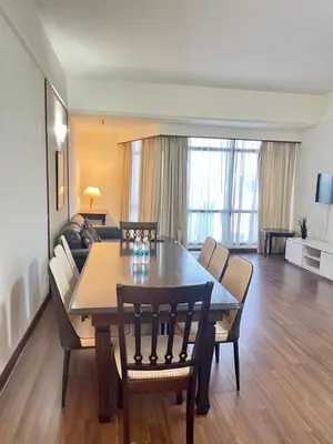 a living room with a table and chairs and a couch at Grand Lumia Suite At Times Square KL in Kuala Lumpur