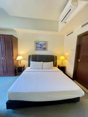 a bedroom with a large white bed with two lamps at Grand Lumia Suite At Times Square KL in Kuala Lumpur