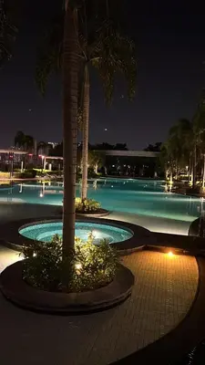 a pool at night with palm trees and lights at Trion Comfort & Luxury Near By Klcc in Kuala Lumpur