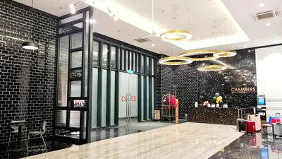 a lobby of a store with a woman standing next to a counter at SUITES At CHAMBERS KLCC KUALALAMPUR in Kuala Lumpur