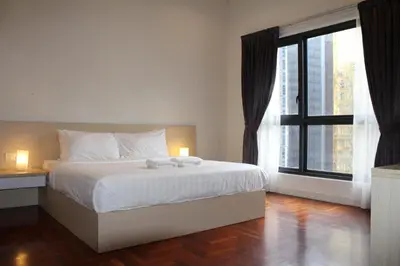 a bedroom with a bed and a large window at The Mews KLCC Service Suites in Kuala Lumpur