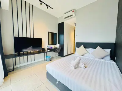 a bedroom with a large white bed with a flat screen tv at Axon Purple Suite Kuala Lampur in Kuala Lumpur