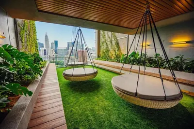 two swings on a balcony with green grass at Ceylonz Suites, Bukit Bintang, Kuala Lumpur in Kuala Lumpur