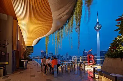 people sitting at tables in a restaurant with a view of the city at Ceylonz Suites, Bukit Bintang, Kuala Lumpur in Kuala Lumpur