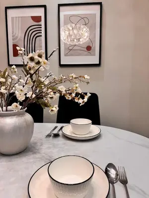 a table with two plates and a vase with flowers at Luxury Sky Homes with KLCC VIEW in Kuala Lumpur