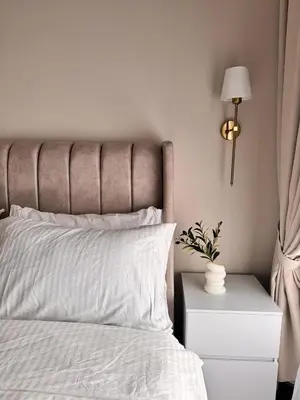 a bed with white sheets and a lamp on a nightstand at Luxury Sky Homes with KLCC VIEW in Kuala Lumpur