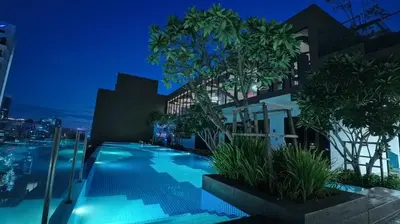 a view of a building with a swimming pool at night at Luxury Suites Majestic Residences at Heart of KLCC in Kuala Lumpur