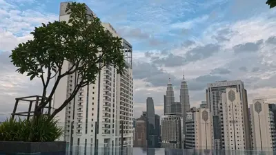 a tree in front of a city skyline at Luxury Suites Majestic Residences at Heart of KLCC in Kuala Lumpur