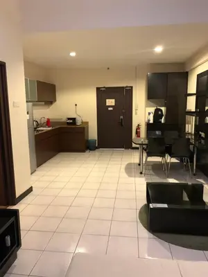 a living room with a table and a kitchen at Sweet cozy house by seri bukit Ceylon in Kuala Lumpur