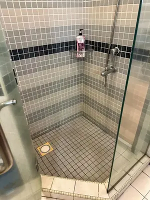 a shower with a glass door in a bathroom at Sweet cozy house by seri bukit Ceylon in Kuala Lumpur