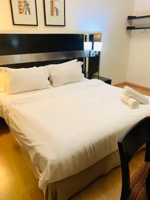 a large white bed with a black headboard at seri bukit ceylon by sweet cozy house in Kuala Lumpur