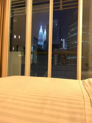 a bed in a bedroom with a view of the city at seri bukit ceylon by sweet cozy house in Kuala Lumpur