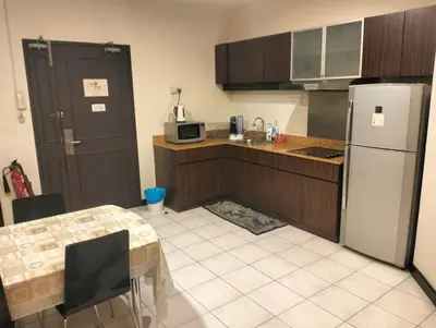 a small kitchen with a table and a refrigerator at seri bukit ceylon by sweet cozy house in Kuala Lumpur