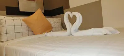 two white swans making a heart on a bed at Majestic Infinity Pool by KLCC in Kuala Lumpur
