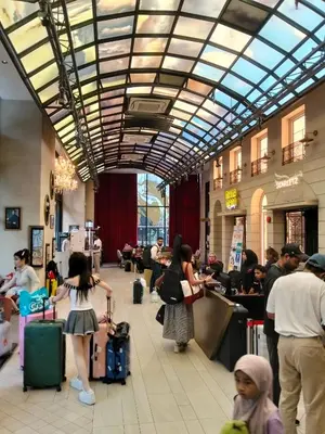 a group of people standing in a lobby with luggage at Scarletz Service Suites KLCC in Kuala Lumpur