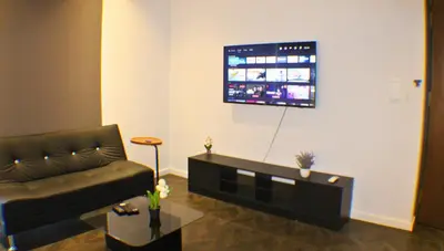 a living room with a couch and a flat screen tv at Scarletz Service Suites KLCC in Kuala Lumpur