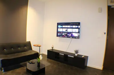 a living room with a couch and a flat screen tv at Scarletz Service Suites KLCC in Kuala Lumpur