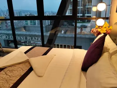 a white couch sitting in front of a window at Hospitality Service Suites Scarlitz KLCC in Kuala Lumpur