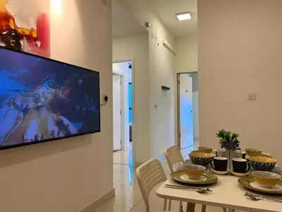 a dining room with a table and a tv on a wall at 4BR KLCC View MRT 2min Free Parking Big Unit in Kuala Lumpur