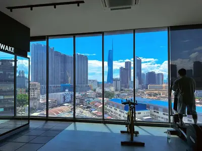a man looking out the window of a building at 4BR KLCC View MRT 2min Free Parking Big Unit in Kuala Lumpur