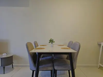 a table with chairs and a vase on top of it at The Majestic Residence Suites By Casabellestay in Kuala Lumpur