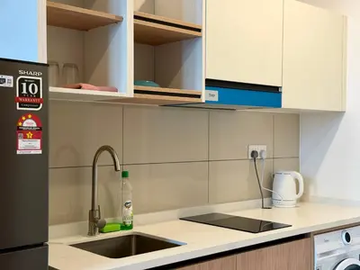 a kitchen with a sink and a refrigerator at The Majestic Residence Suites By Casabellestay in Kuala Lumpur