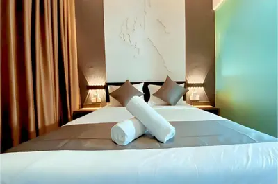 a bedroom with a white bed with two pillows at Hotel Pollodium Chinatown KL in Kuala Lumpur