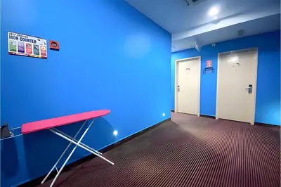 an empty room with a red table and blue walls at Hotel Pollodium Chinatown KL in Kuala Lumpur