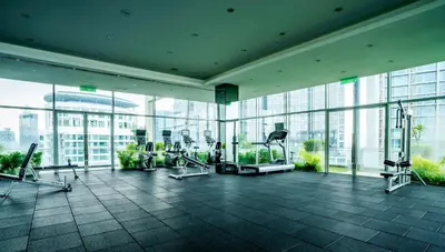 a gym with cardio equipment in a building with windows at 188 Suites by KidsCastle in Kuala Lumpur