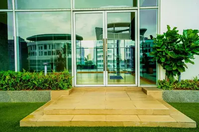 a glass building with a walkway in front of it at 188 Suites by KidsCastle in Kuala Lumpur
