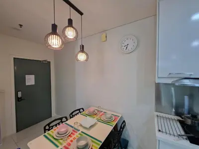 a kitchen with a table and a clock on the wall at Cozy Family Suite 5pax KLCC by SS HOME in Kuala Lumpur