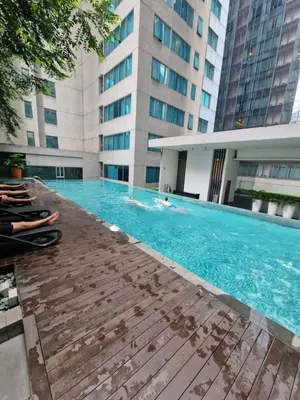 a swimming pool in a building with people in it at Cozy Family Suite 5pax KLCC by SS HOME in Kuala Lumpur
